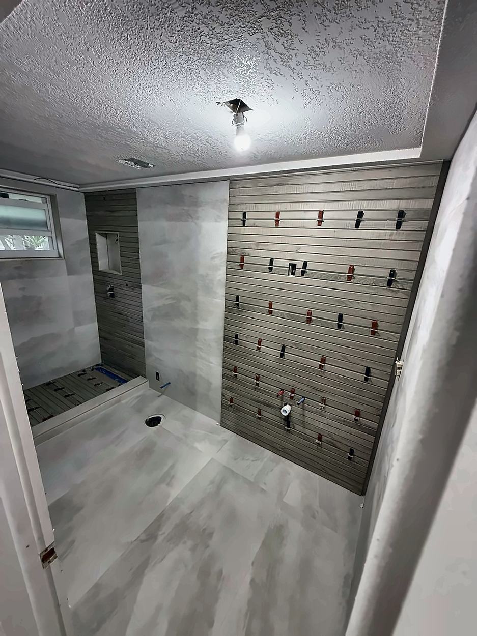 Large-format tile set across the walls with leveling clips at every joint and string lines run