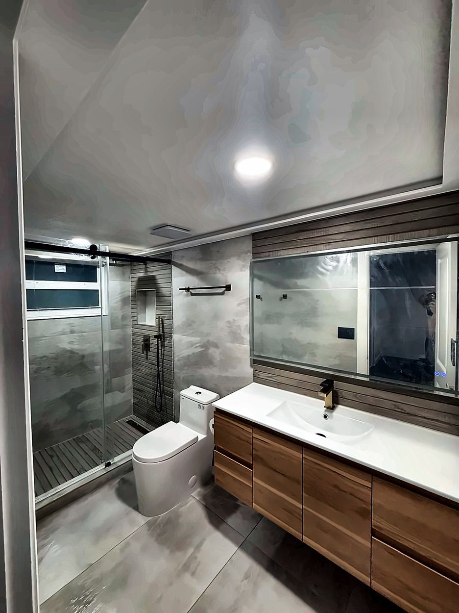 Full view of the timber vanity bathroom showing the stone-look floor and shower niche